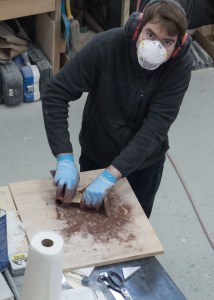 Marsden sanding the bottom paint off the propeller strut.