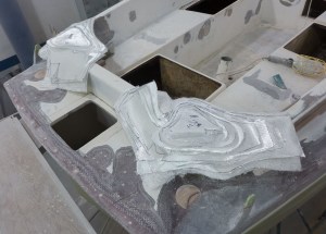 This gives an idea of the glassing. The piles of glass are going to be laminated on to the two corners of the transom with lots of resin. We will try not to drip too much.